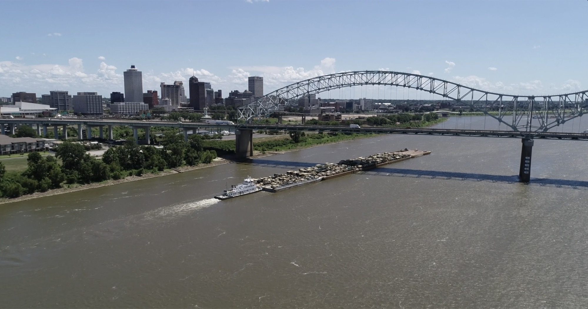 Military equipment barges passing Memphis on the Mississippi River