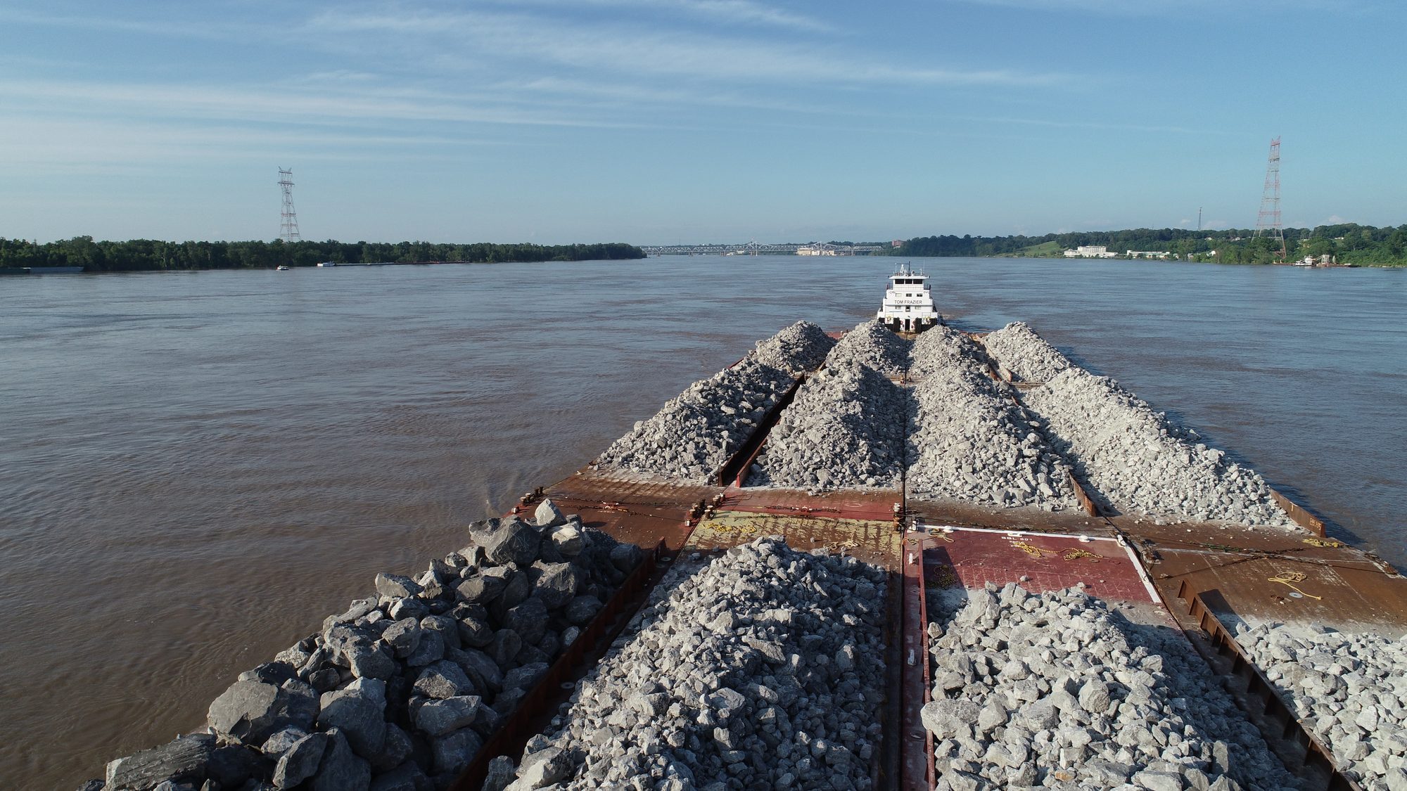 Towboat pushing rock-loaded barges
